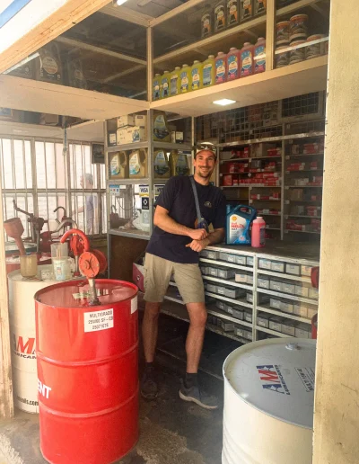 Photo de Simon au comptoir d'un vendeur d'huile moteur et de liquides pour voiture