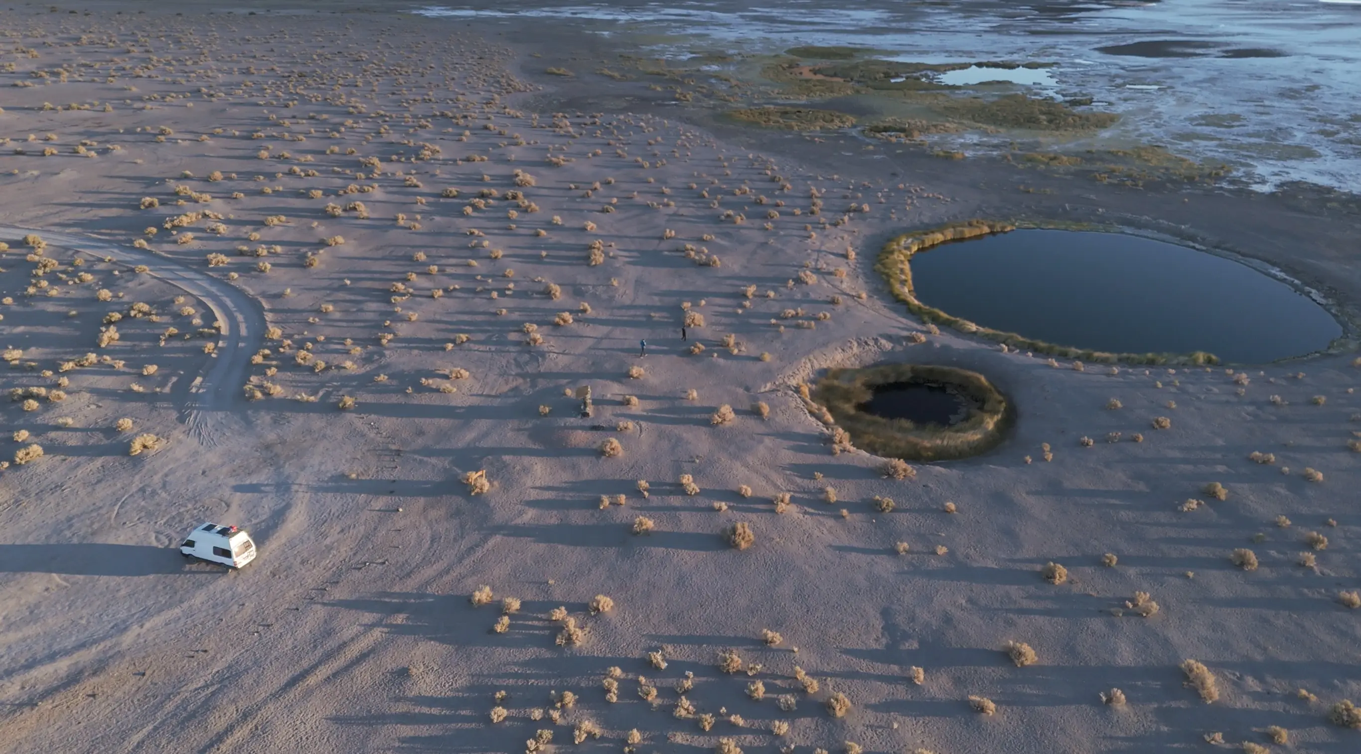 Van aménagé et Ojos del Campo, Puna Argentina Prise de vue aérienne du van aménagé à côté des lacs d'eau salée dans le salar d'Antofalla, un désert de sel dans la Puna, une région du nord de l'Argentine